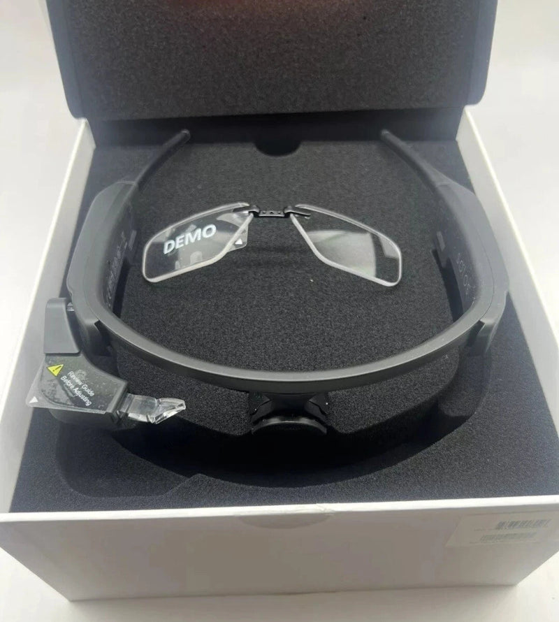 Eyeglasses with 'DEMO' label inside a gray case on a white background