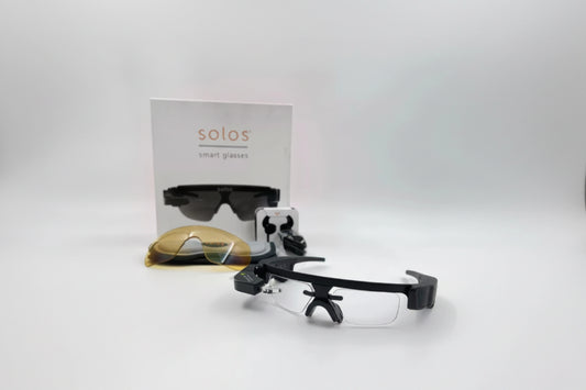 Black smart glasses with a clear lens on a white background, featuring the 'solos' brand.